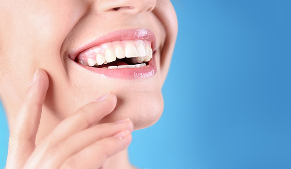 smiling woman with white teeth showing joy and beauty in a blue background perfect smile tips for five star teeth