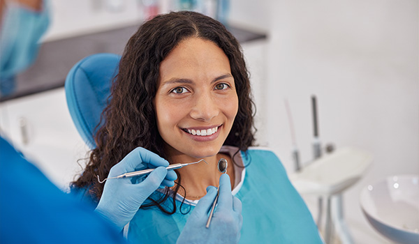 smiling woman at dental checkup with dentist tools in hand bright smile six dental health care 6