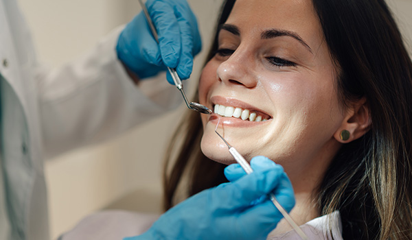 dental checkup with smiling woman showing healthy teeth during professional cleaning in a clinic featuring top 10 dental care tips