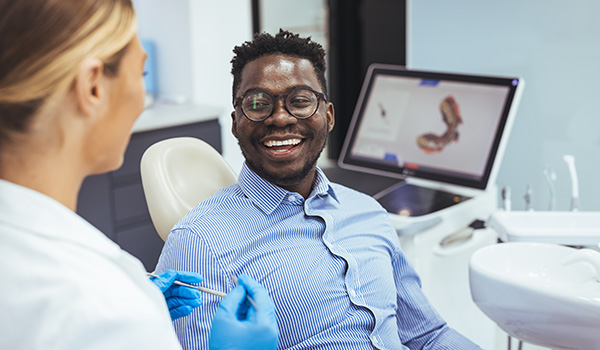 smiling patient in dental office with female dentist working on oral health consultation and 9 dental treatments in background